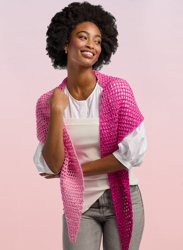 Image of a lady holding a scarf pattern made with premier yarns everyday gradient yarn.