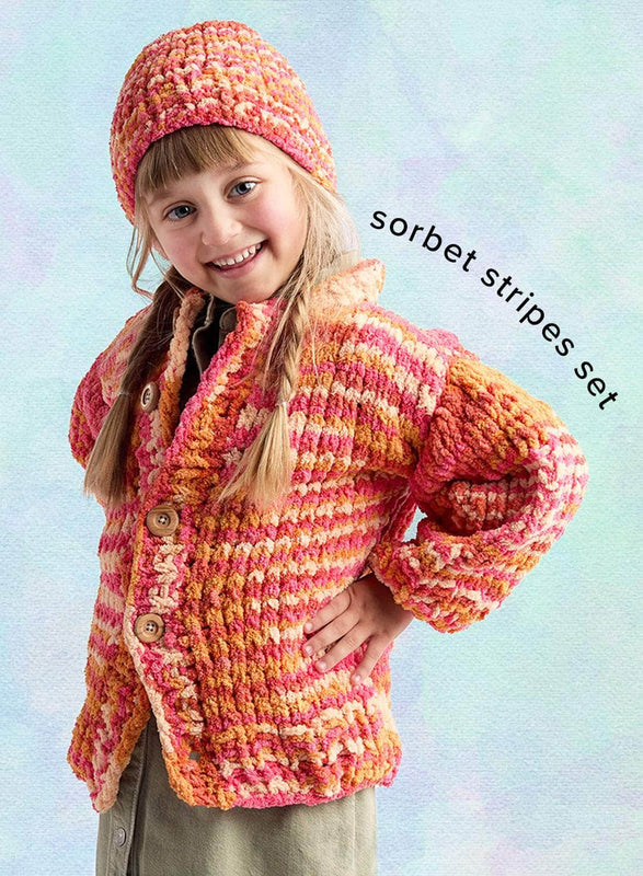 A pastel watercolor background featuring a crochet project with a girl in an orange and pink crocheted cardigan with a matching beanie ('sorbet stripes set').