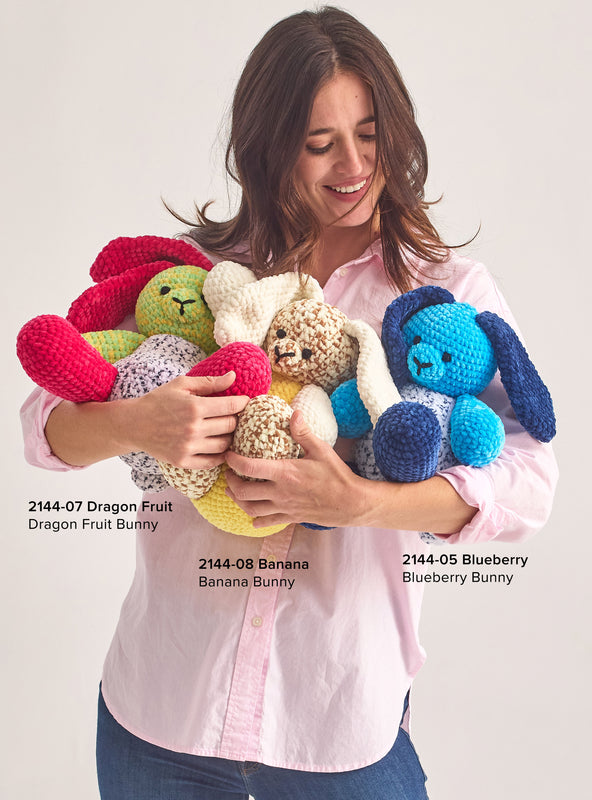 Image of woman holding various bunny patterns created with Chunky Fruits yarn 